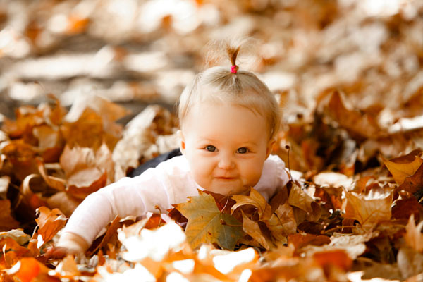 Baby in autumn leaves