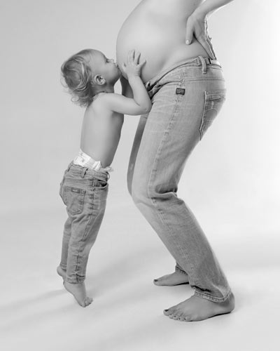 Young child kissing mums belly